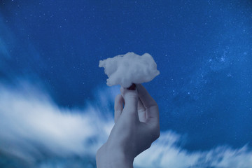 Hand holding a cloud with space background. 