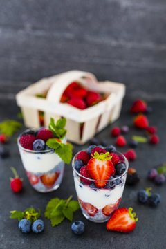 Yogurt with fresh berries fruit and chia seeds on dark background. 