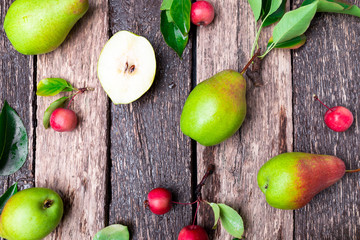 Pear and small apple on wooden rustic background. Top view. Frame. Autumn harvest.
