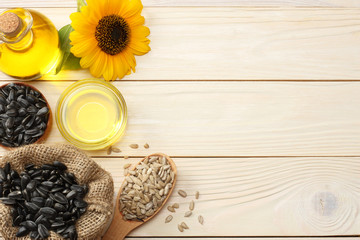 Sunflower oil, seeds and flower on white wooden background. top view with copy space