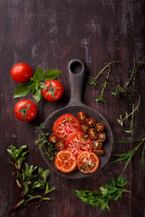 Sliced fresh red tomatoes with spices and herbs
