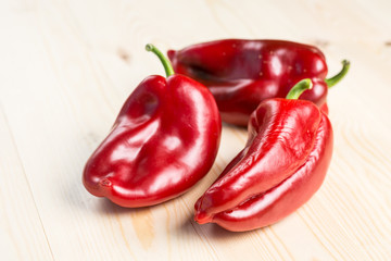 Fresh red paprika on the wooden table with native sunlight