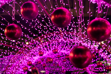 Colorful Xmas decoration of many LED light. Decorative Christmas balls hang out on the outdoor decoration of the construction.