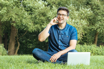 Young man using smartphone while sitting on grass