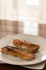 Flat lay fried grilled paprika in the eggs served on the white plate above brown table boards