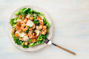 Overhead photo of shrimp Caesar salad with copyspace