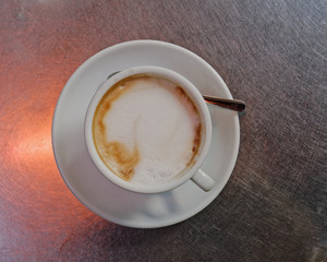 hot caffe latte cup on metallic table