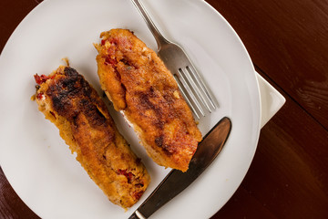 Grilled and fried in eggs paprika with knife and fork on the pla