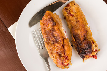Grilled and fried in eggs paprika with knife and fork on the plate