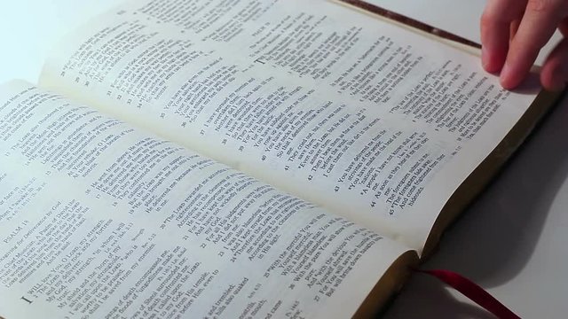 Man Leafing Through The Page Of Bible