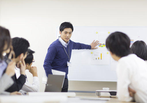 Businessman giving presentation to colleague in office meeting
