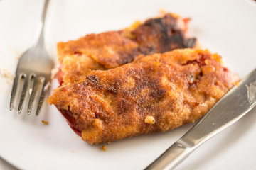 Grilled and fried in eggs paprika with knife and fork on the plate