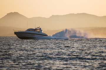 Fast motor speed boat at sunset