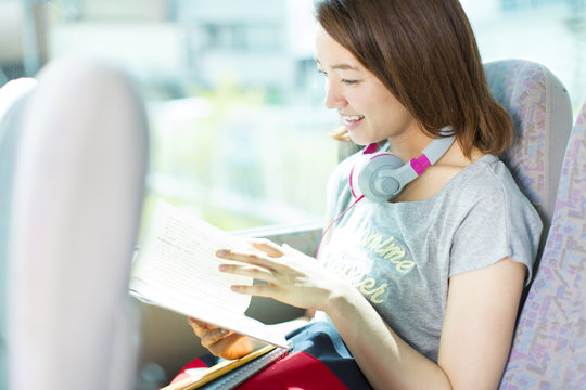 Young Woman reading Book in Bus
