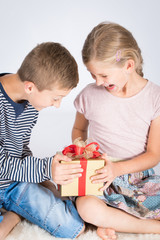 Boy and girl feeling excited and happy with present 