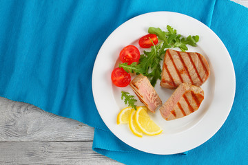 grilled tuna steak with salad and lemon