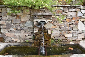 Foto auf Acrylglas Brunnen Fontaine en pierre sèche dans le cap Corse