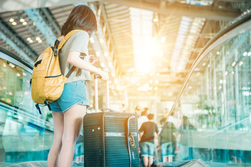 Asian women were carrying luggage around the international airport. She was traveling abroad to travel on weekends.