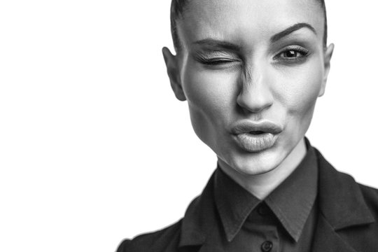 Beautiful woman in black suit winks and making a kiss
