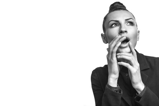 Beautiful young fashion woman is surprised and flightendly. Hair in a bun. isolated on white background. free space. high resolution monochrome studio shot. Banner template.
