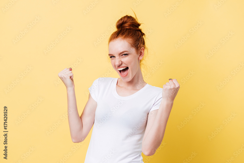 Poster Screaming happy ginger woman in t-shirt looking at the camera