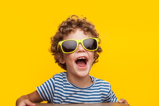Adorable kid in bright sunglasses on orange