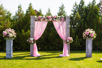 Tender pink and white wedding ceremony decorations on the lawn