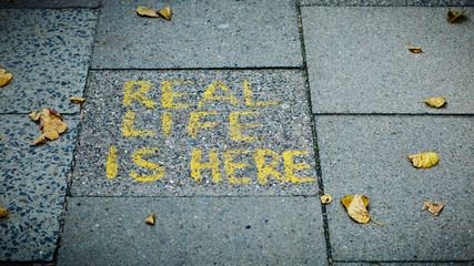 Real Life is here Gaffiti Schriftzug auf einem Bürgersteig - Real Life is here Gaffito writing on a sidewalk