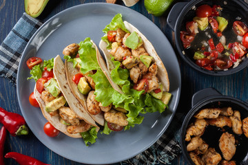 Authentic mexican tacos with chicken and salsa with avocado, tom
