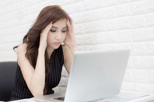 Asian Woman using Laptop with serious emotion, woman boring to work at laptop, woman working concept.