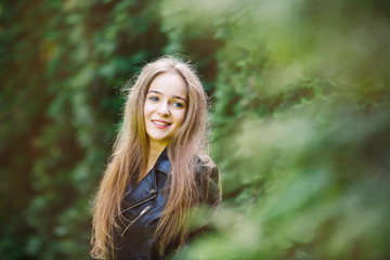 Naklejka premium Portrait of the cheerful young girl in a forest