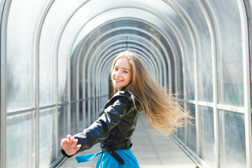 Portrait of the cheerful young girl in a glass arch