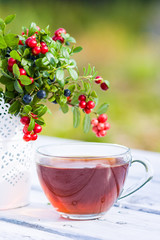 Cup of tea and berries on table in autumn