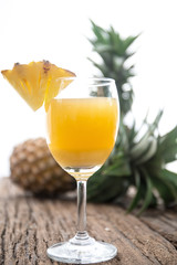 Glass of pineapple juice onwood table