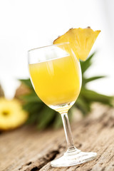 Glass of pineapple juice onwood table