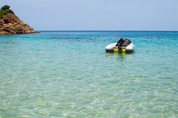 Inflatable dinghy boat with outboard motor moored in tropical sea