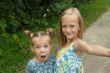 Little girls taking selfie Two sisters fooling
