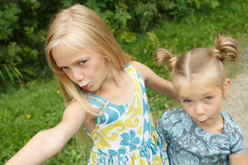 Little girls taking selfie Two sisters fooling
