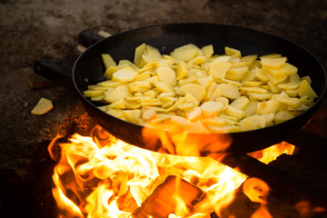 Potatoes fried in a frying pan in the open air