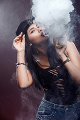 Young sexy woman is vaping. A cloud of vapor. Studio shooting.