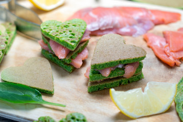 Pancakes of spinach. On the table along with the fish, spinach and lemon wedges. Shallow DOF