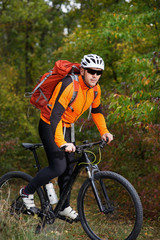 Fototapeta na wymiar Mountain biking down the trail. Tourist with backpack travel on bike.