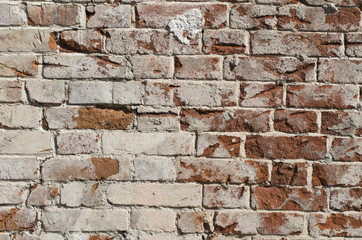 Background of old cracked brick wall with traces of whitewash