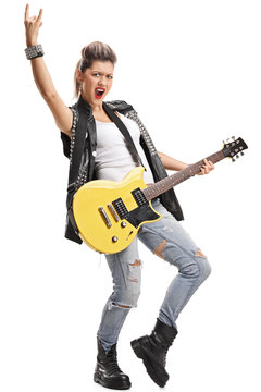 Punk girl with an electric guitar making rock hand gesture