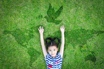 World peace day and International day of peace concept with peaceful mind kid resting in clean natural environment on eco friendly green lawn world map and dove