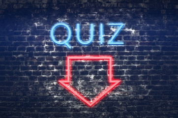 Quiz neon sign on dark brick wall background