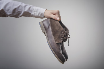 Businessman`s hand with brown leather shoes