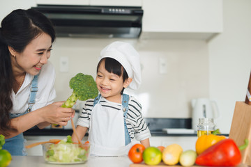 Mother with her daughter in the kitchen cooking together