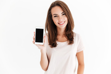 Joyful brunette woman showing blank smartphone screen - obrazy, fototapety, plakaty