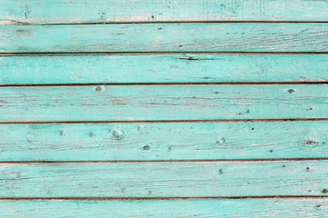 Wooden texture of turquoise color. Old painted fence of boards.